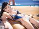 A woman in a blue bikini laying on a beach.