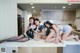 A group of three women sitting on top of a kitchen counter.