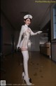 A woman dressed as a nurse in a hospital hallway.