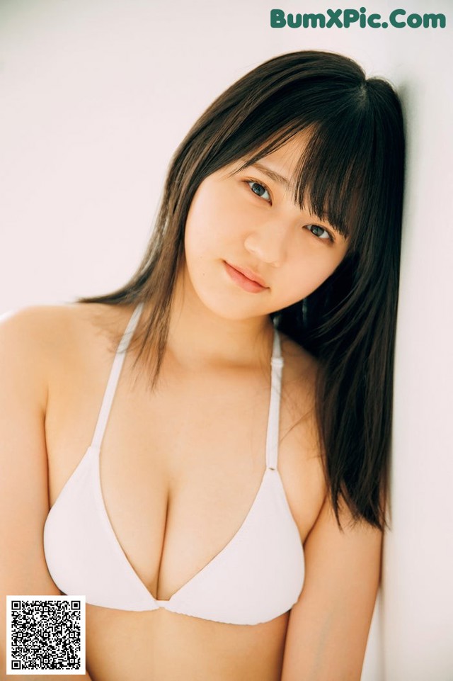 A woman in a white bikini posing for a picture.