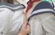 A woman in a sailor outfit is touching another woman's breast.