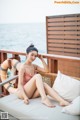 A woman in a pink bathing suit sitting on a couch.