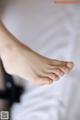 A close up of a woman's bare feet on a bed.