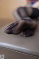 A close up of a person's feet in black stockings.