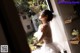 A woman in a wedding dress looking out a window.