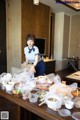 A woman standing in front of a table full of food.