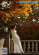 A woman in a white dress standing on a bridge.