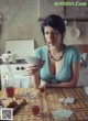 A woman sitting at a table smoking a cigarette.