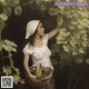 A woman holding a basket of grapes in a vineyard.