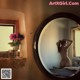 A naked woman standing in front of a mirror.