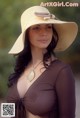 A woman wearing a large hat on a beach.