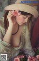 A woman in a straw hat with a flower in her hair.