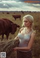 A woman standing in a field holding a bunch of hay.