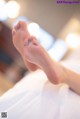 A woman's bare feet on a bed in a room.