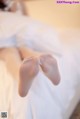 A woman laying on a bed with her feet up.