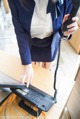 A woman in a business suit is using a phone.