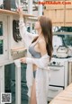 A woman standing in a kitchen next to a stove.