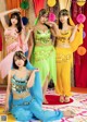 A group of women dressed in brightly colored outfits posing for a picture.