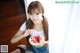 A woman sitting on the floor eating a slice of watermelon.