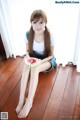 A woman sitting on the floor eating a slice of watermelon.