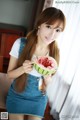 A woman holding a slice of watermelon in her hand.