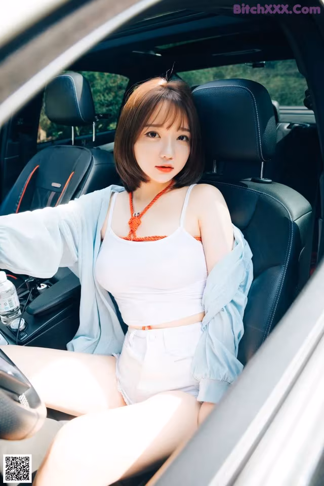 A woman sitting in the driver's seat of a car.