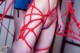 A woman in a red string bikini with a tattoo on her back.